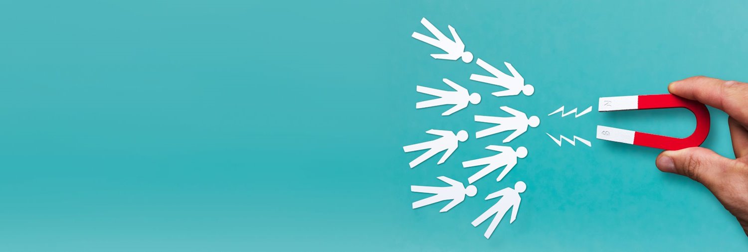 white paper cut-out figures on a teal background being drawn in by a magnet