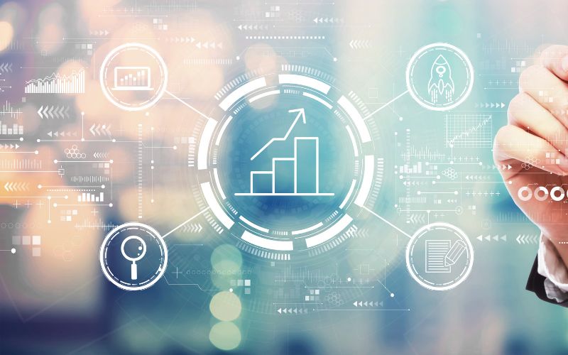 hand with marker writing on a screen where there are different business and marketing graphics