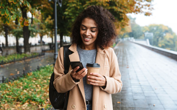 woman walking down street looking at phone