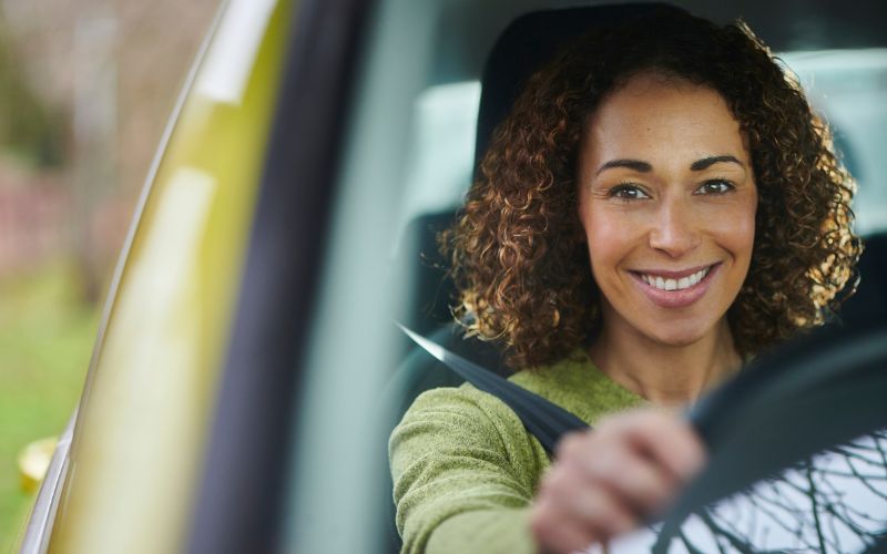 car_wash_customer_convenience.jpg woman smiling behind wheel of car