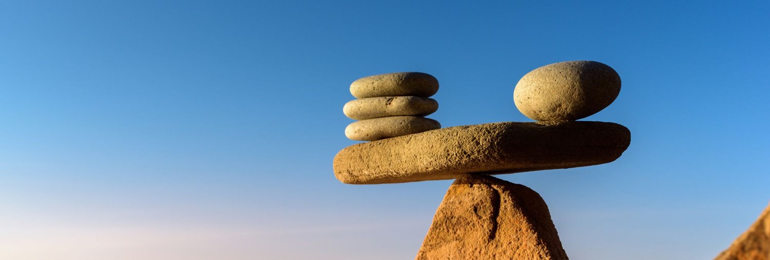 rocks balancing on larger rocks against a blue sky