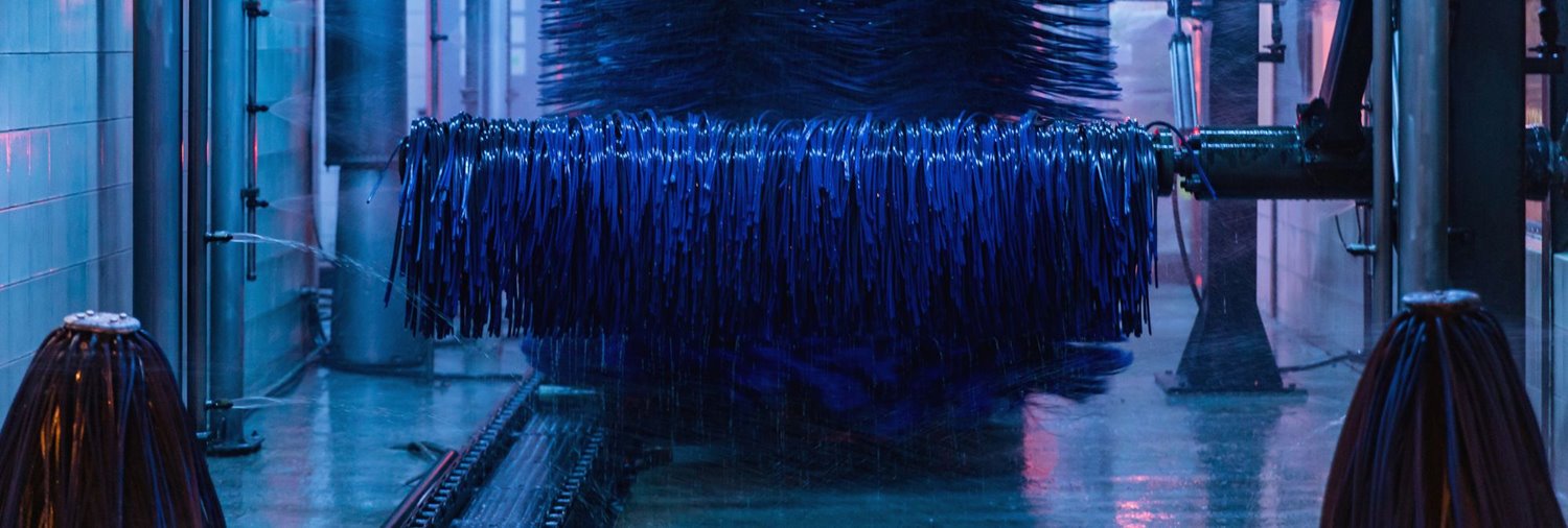 inside a running car wash tunnel with blue wraps