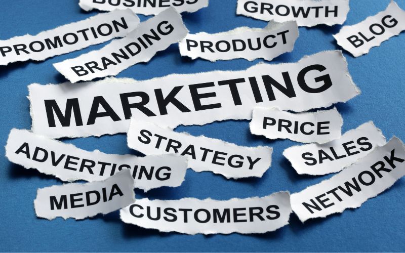 Marketing terms scattered on white strips of paper on a blue background