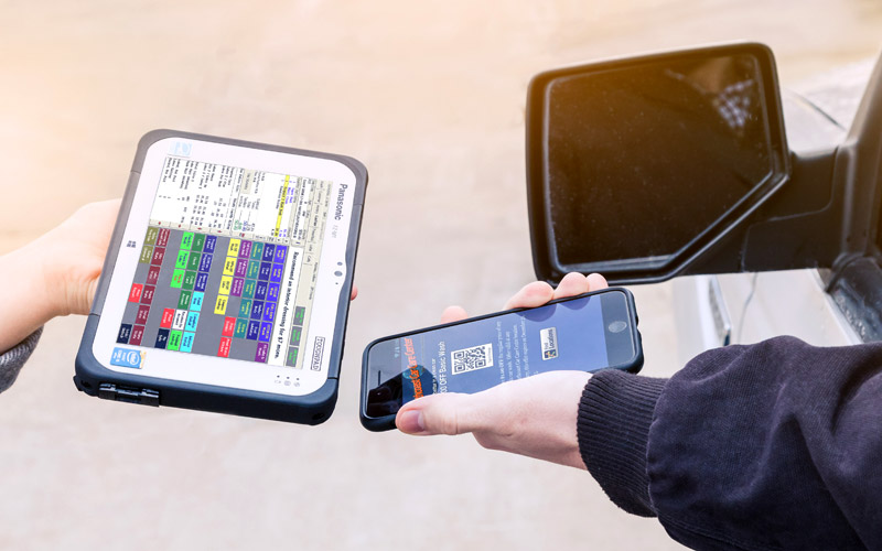car wash attendant scanning a customer's cell phone with drb's tablet touchscreen terminal
