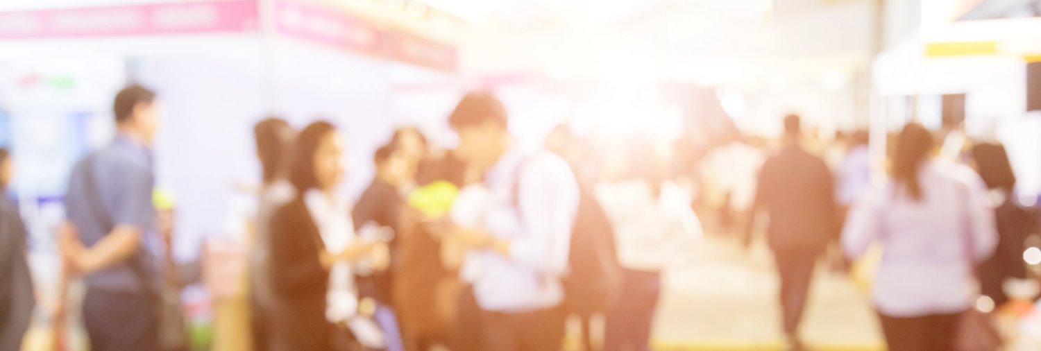 out of focus photo of a crowd of people at a tradeshow