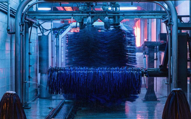 inside a running car wash tunnel with blue wraps