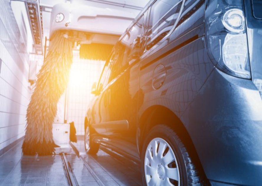 mini van in car wash pay with sun shining at exit