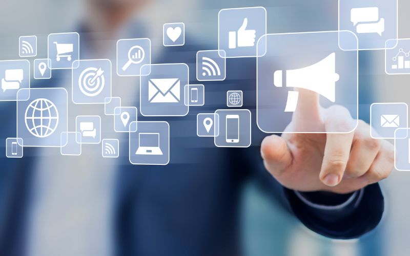 hand touching megaphone icon on a screen full of marketing icons