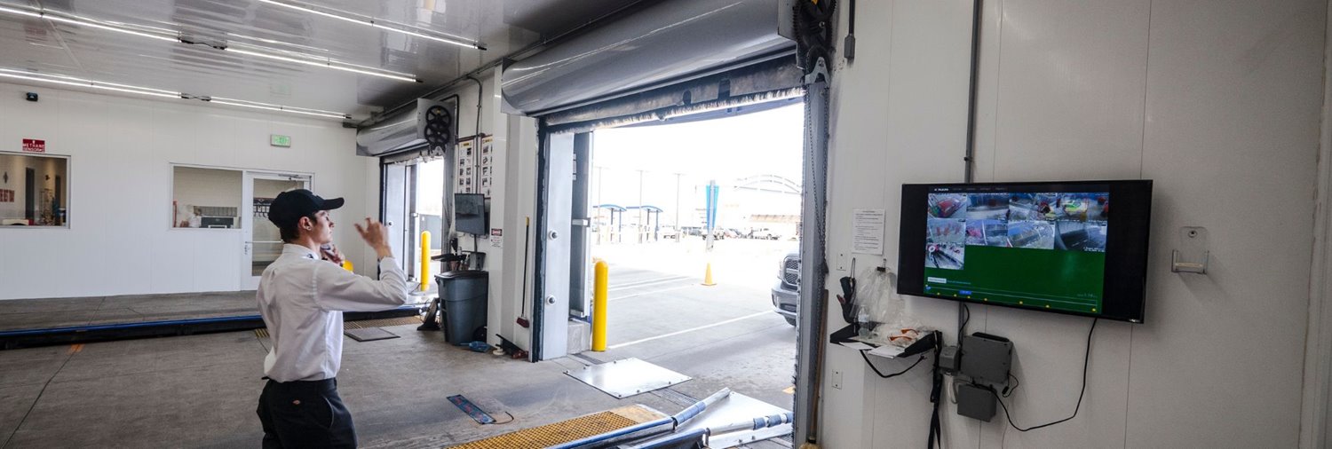 car wash attendant guiding car into tunnel at entrance with the NoPileups terminal in vision