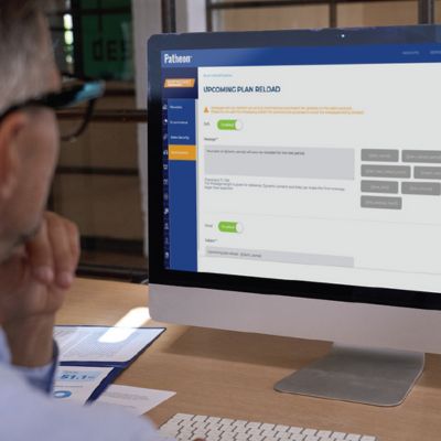 patheon.jpg man looking at computer screen displaying patheon car wash management platform