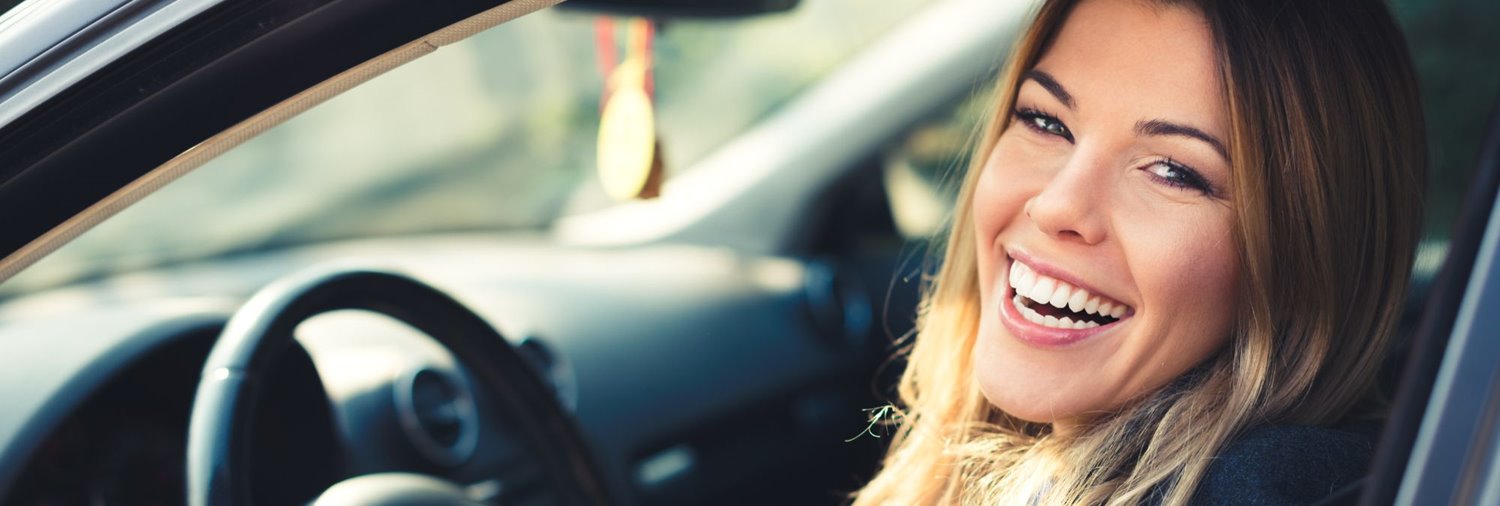 Smiling woman behind wheel of car
