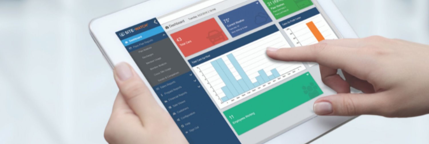 close up of someone using a tablet with sitewatch web car wash reports on it