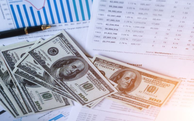 cash laying on printed reports